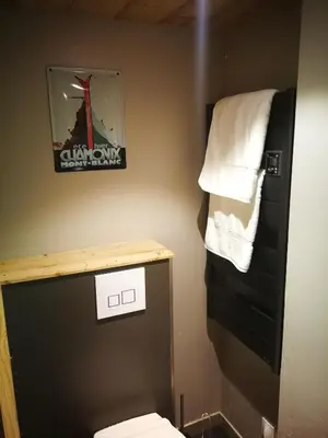 a bathroom with a toilet and a sign on the wall at Le Gypaète in Chamonix-Mont-Blanc