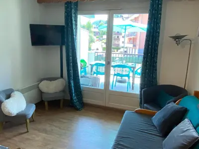 a living room with a couch and a clock on the wall at Grand Panorama T2 aux pieds des télécabines 