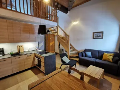 a kitchen and a living room with a couch and a table at Le Mallory in Chamonix-Mont-Blanc