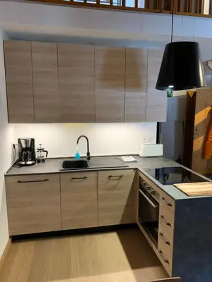 a kitchen with wooden cabinets and a sink at Le Mallory in Chamonix-Mont-Blanc