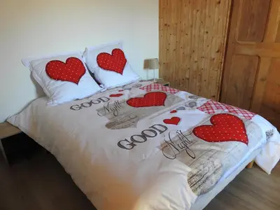 a bed with heart pillows on top of it at Chalet avec terrasse et vue sur le Mt-Blanc in Sallanches