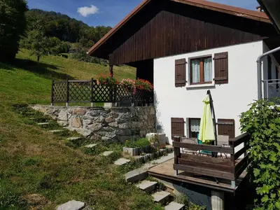 a white house with a bench and a window at Chalet avec terrasse et vue sur le Mt-Blanc in Sallanches