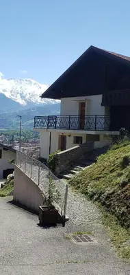 a house on top of a hill with a balcony at Chalet avec terrasse et vue sur le Mt-Blanc in Sallanches