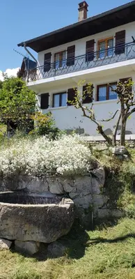 a white house with a tree in front of it at Chalet avec terrasse et vue sur le Mt-Blanc in Sallanches