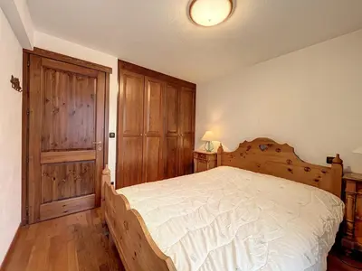 a bedroom with a bed and a wooden door at Appartement cosy au centre de Chamonix avec parking - FR-1-507-42 in Chamonix-Mont-Blanc