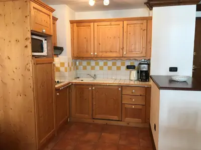 a small kitchen with wooden cabinets and a sink at Appartement cosy au centre de Chamonix avec parking - FR-1-507-42 in Chamonix-Mont-Blanc