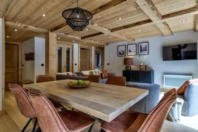a dining room and living room with a wooden table and chairs at Residence la Blaitiere in Chamonix-Mont-Blanc