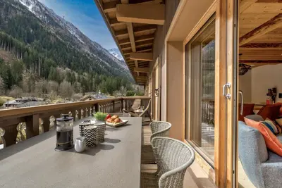 a balcony with a table and chairs and a view at Residence la Blaitiere in Chamonix-Mont-Blanc