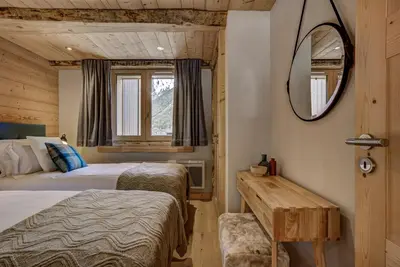 a bedroom with two beds and a mirror at Residence la Blaitiere in Chamonix-Mont-Blanc