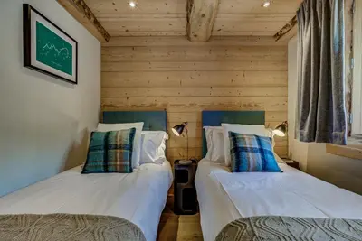 two twin beds in a room with wooden walls at Residence la Blaitiere in Chamonix-Mont-Blanc