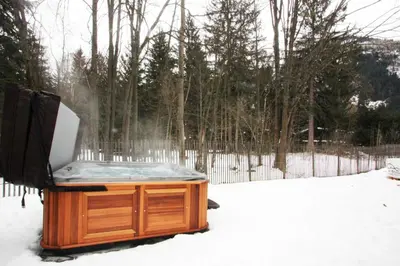 a hot tub sitting in the snow in a yard at Chalet des Amis appt 1 - Chamonix All Year in Chamonix-Mont-Blanc