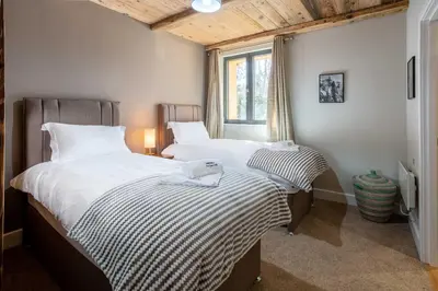 two twin beds in a bedroom with a window at Chalet des Amis appt 1 - Chamonix All Year in Chamonix-Mont-Blanc