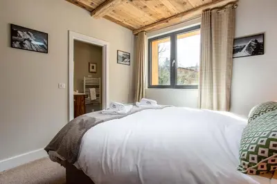 a bedroom with a white bed and a window at Chalet des Amis appt 1 - Chamonix All Year in Chamonix-Mont-Blanc