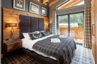 a bedroom with a large bed and a large window at Chalet des Amis appt 2 - Chamonix All Year in Chamonix-Mont-Blanc