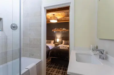 a bathroom with a bath tub and a bedroom at Chalet des Amis appt 2 - Chamonix All Year in Chamonix-Mont-Blanc