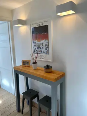 a table with two stools and a picture on the wall at Appartement Odyssée - Welkeys in Megève