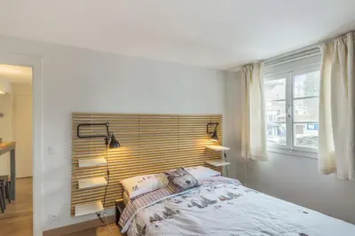 a bedroom with a bed and two lamps and a window at Appartement Odyssée - Welkeys in Megève