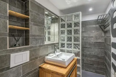 a bathroom with a sink and tiled walls at Appartement Odyssée - Welkeys in Megève