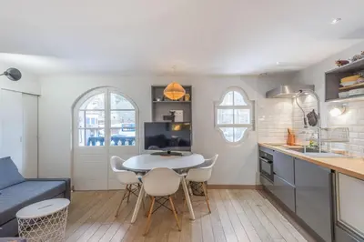 a kitchen with a table and chairs in a room at Appartement Odyssée - Welkeys in Megève