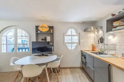 a kitchen with a white table and chairs in a kitchen at Appartement Odyssée - Welkeys in Megève