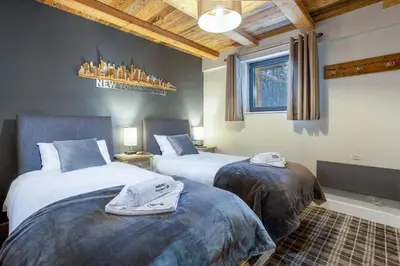 two beds in a hotel room with two at Chalet des Amis- Chamonix All Year in Chamonix-Mont-Blanc