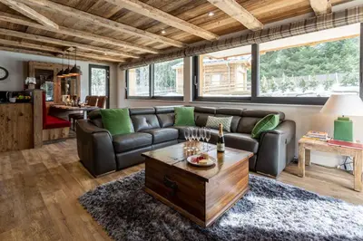 a living room with a leather couch and a table at Chalet des Amis- Chamonix All Year in Chamonix-Mont-Blanc