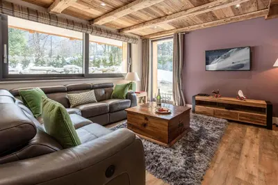 a living room with a couch and a table at Chalet des Amis- Chamonix All Year in Chamonix-Mont-Blanc