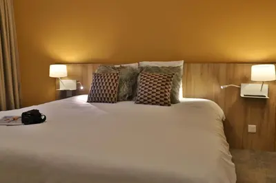 a bedroom with a large white bed with two lamps at SOWELL HOTELS Mont Blanc et SPA in Saint-Gervais-les-Bains