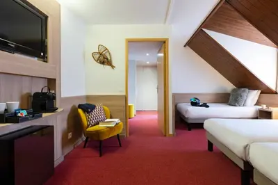 a hotel room with two beds and a tv at SOWELL HOTELS Mont Blanc et SPA in Saint-Gervais-les-Bains