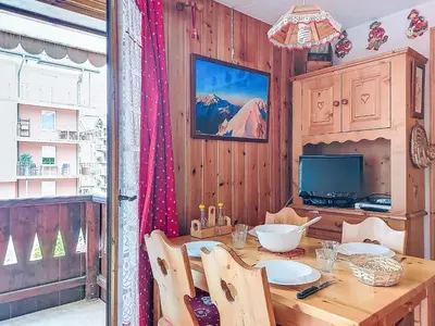 a wooden dining room with a table and a television at Apartment Jardins Alpins by Interhome in Saint-Gervais-les-Bains