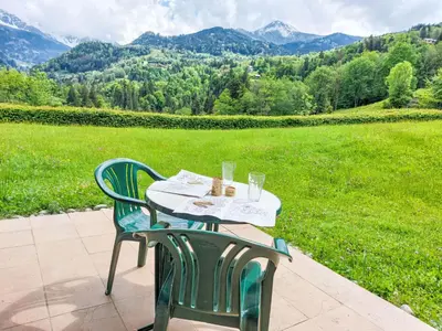 a living room with a table and a blue couch at Apartment Le Parc du Mont Joly-3 by Interhome in Saint-Gervais-les-Bains