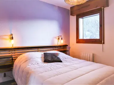 a bedroom with a large bed with a window at Apartment L'Espace Montagne-16 by Interhome in Chamonix-Mont-Blanc