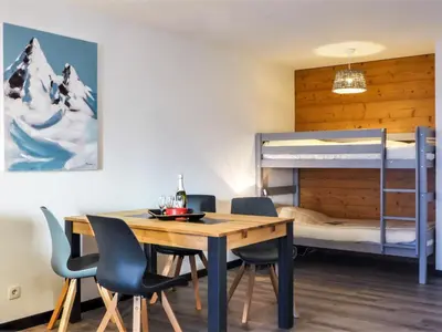 a dining room with a table and chairs and bunk beds at Apartment L'Espace Montagne-16 by Interhome in Chamonix-Mont-Blanc