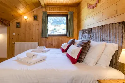 a bedroom with a large bed in a log cabin at Les Clochettes in Megève