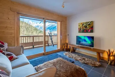 a living room with a couch and a large window at IRIS A3 Chalet Delys in Les Houches