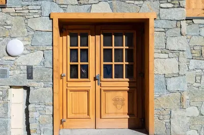 a wooden door in a stone building with a window at IRIS A3 Chalet Delys in Les Houches