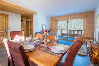 a dining room with a wooden table and chairs at IRIS A3 Chalet Delys in Les Houches