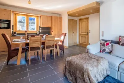 a kitchen and a living room with a table and a couch at IRIS A3 Chalet Delys in Les Houches