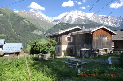 a couple of buildings with mountains in the background at Les Passereaux 2 in Saint-Gervais-les-Bains