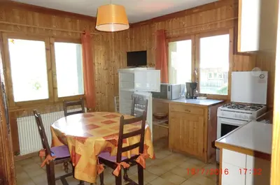 a kitchen with a table and a kitchen with a stove and refrigerator at Les Passereaux 2 in Saint-Gervais-les-Bains
