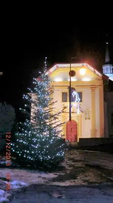 a christmas tree with lights in front of a building at Les Passereaux 2 in Saint-Gervais-les-Bains