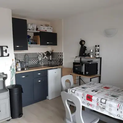 a kitchen with a table and a kitchen with a table and chairs at Le chalet des neiges 2 est au calme situé à 5 mn à pied du centre il est composé d'1 chambre avec lit double plus canapé convertible parking privé sur place et arrêt navette gratuite à 30 m in Les Carroz d'Araches