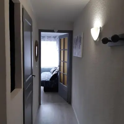a hallway with a door leading to a bedroom at Le chalet des neiges 2 est au calme situé à 5 mn à pied du centre il est composé d'1 chambre avec lit double plus canapé convertible parking privé sur place et arrêt navette gratuite à 30 m in Les Carroz d'Araches