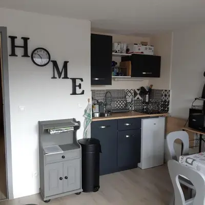 a kitchen with a clock on the wall at Le chalet des neiges 2 est au calme situé à 5 mn à pied du centre il est composé d'1 chambre avec lit double plus canapé convertible parking privé sur place et arrêt navette gratuite à 30 m in Les Carroz d'Araches