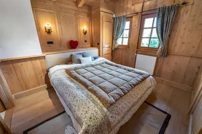 a bedroom with a bed in a room with wooden walls at Beautiful Nirvana in Megève