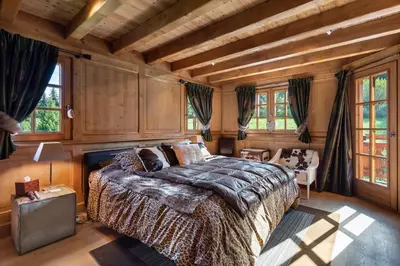 a bedroom with a large bed in a room with wooden walls at Beautiful Nirvana in Megève