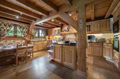 a large kitchen with wooden cabinets and a wooden table at Beautiful Nirvana in Megève