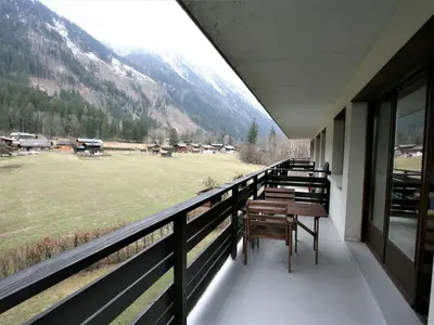 a balcony with benches and a view of a field at Charmant T2 Chamonix avec balcon, accepte animaux - FR-1-507-45 in Chamonix-Mont-Blanc