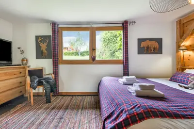 a living room with a fireplace and a staircase at Chalet Taconnaz - Warm & Cosy 3BR Chalet with Fireplace in Nature - By Cozee Rentals in Les Houches