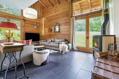 a living room with a couch and a fireplace at Chalet Taconnaz - Warm & Cosy 3BR Chalet with Fireplace in Nature - By Cozee Rentals in Les Houches